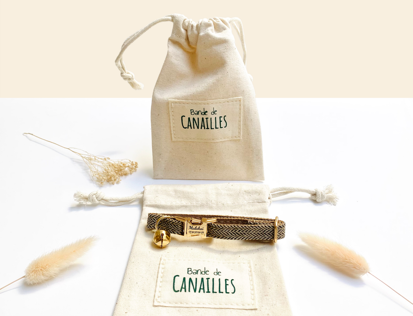Pochette cadeau en tissu beige avec étiquette « Bande de CANAILLES », décorée de rubans et d’accessoires dorés.