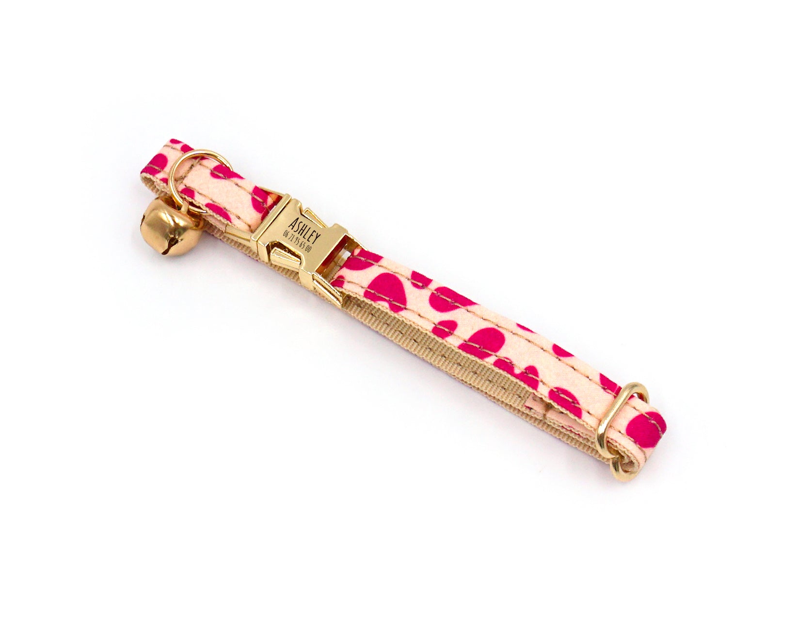 Collier chat personnalisé Léopard Rose avec clochette et boucle dorées, motif félin rose sur fond clair.