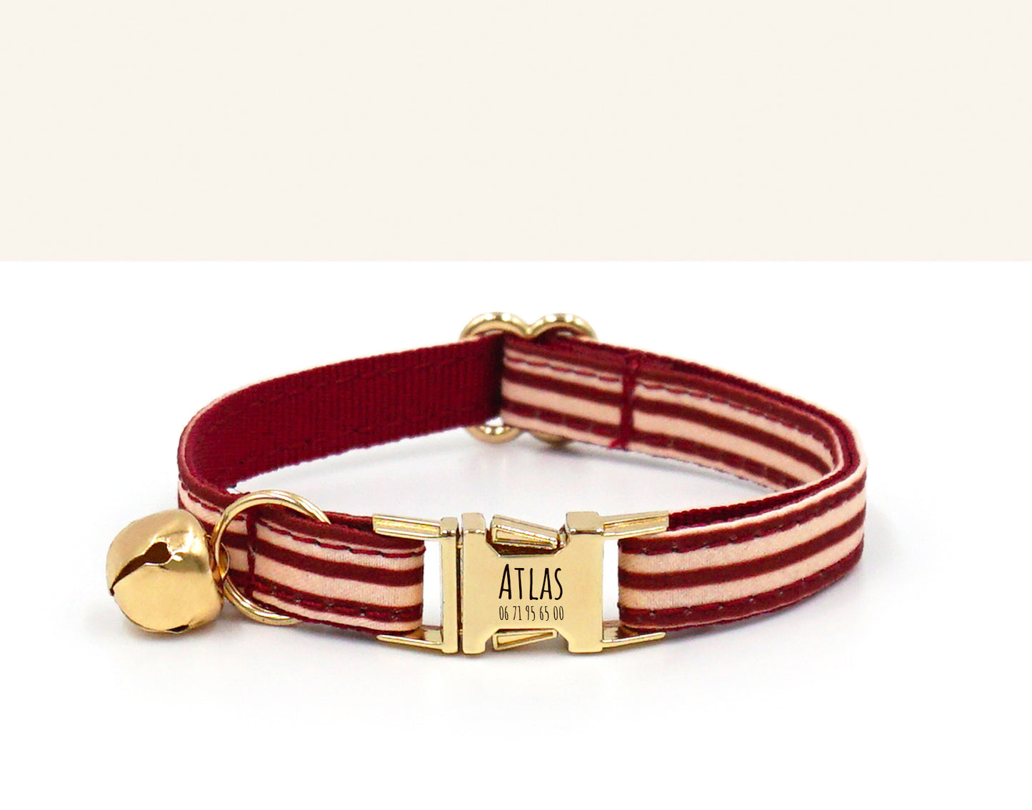 Collier chat personnalisé en coton rayé Bordeaux avec fermoir doré et petit charm tête de chat, épingle Atlas gravée.