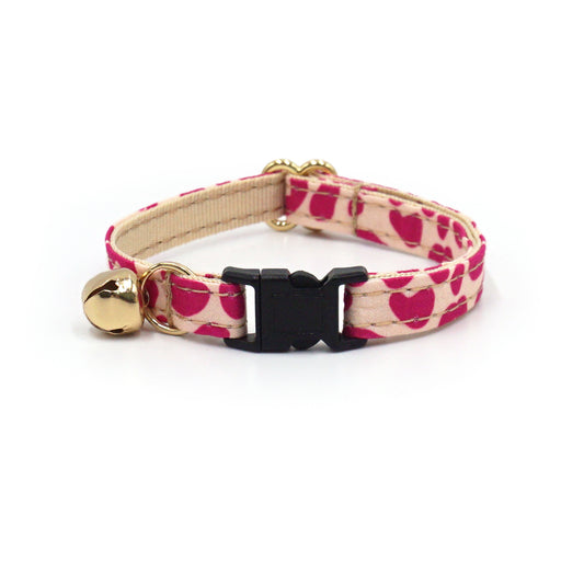 Collier chat antiétranglement en coton couleur léopard rose avec boucle noire et petit pendentif doré.
