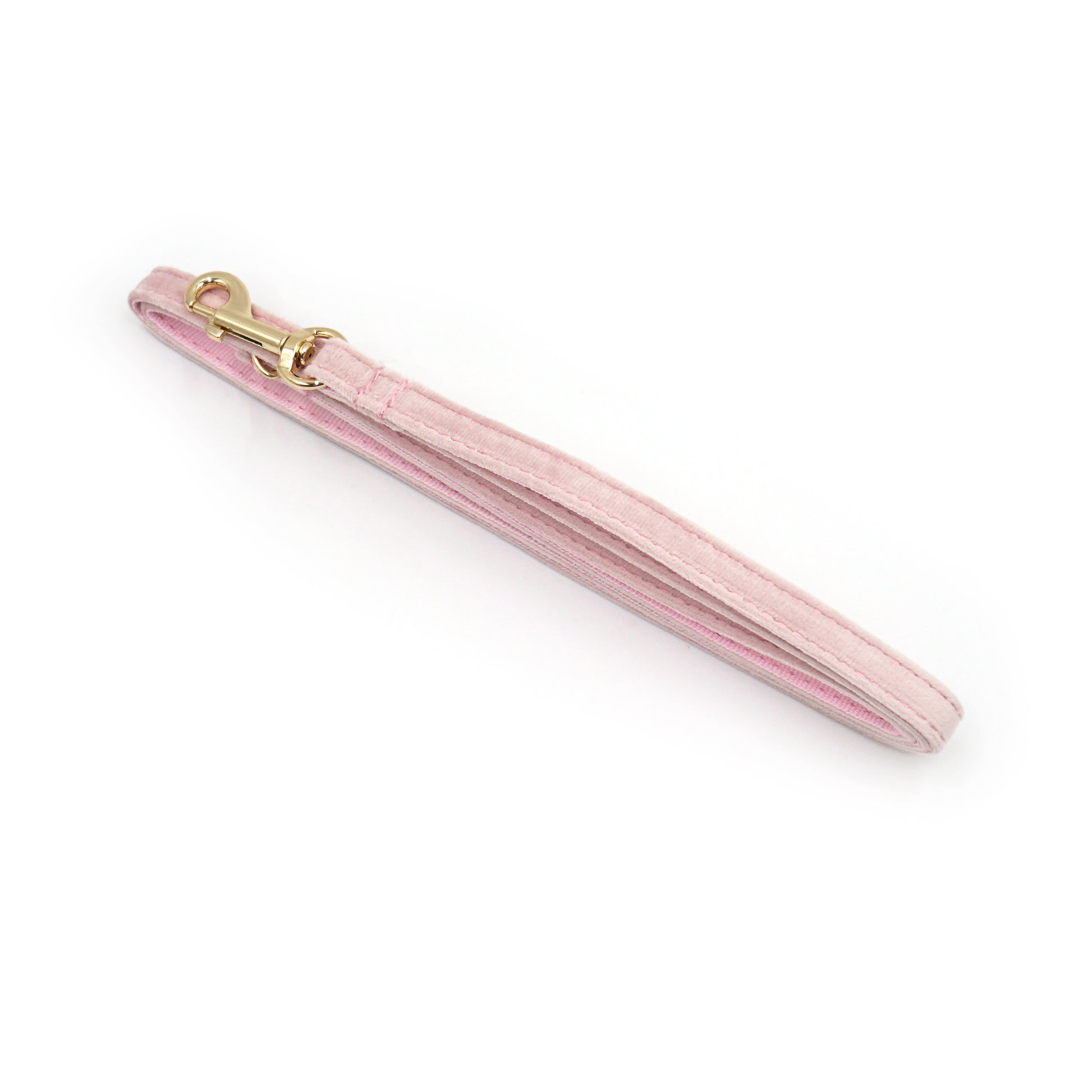 Laisse chat et chaton velours lisse rose avec mousqueton doré, vue en angle isolée.